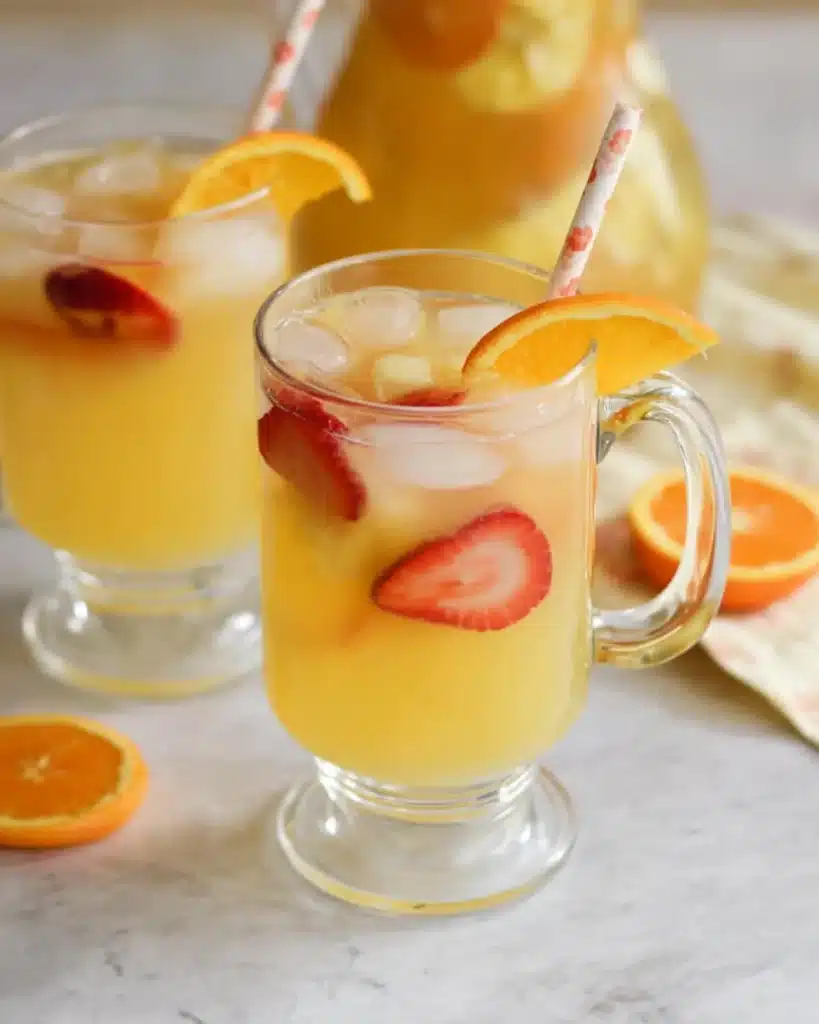 Easy Breakfast Punch Recipe: A Refreshing Morning Favorite 2 Glasses of breakfast punch with ice and strawberries on light table