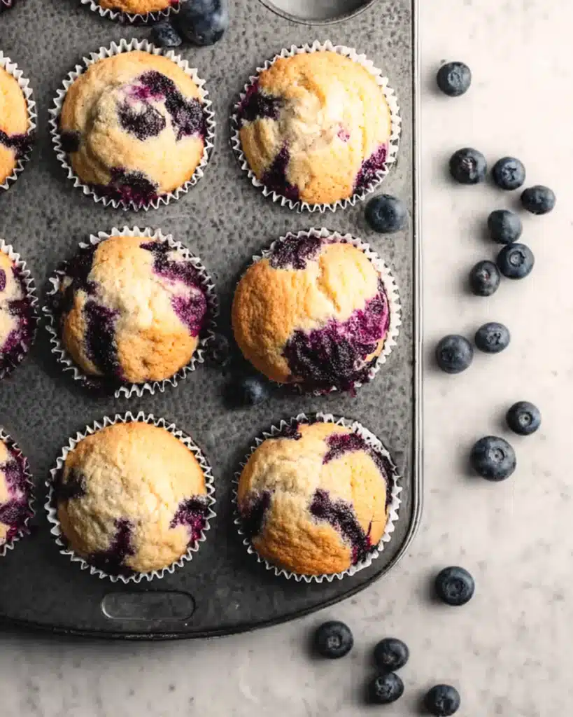 Greek Yogurt Blueberry Protein Muffins 3 Freshly baked Greek yogurt blueberry protein muffins in a muffin tin