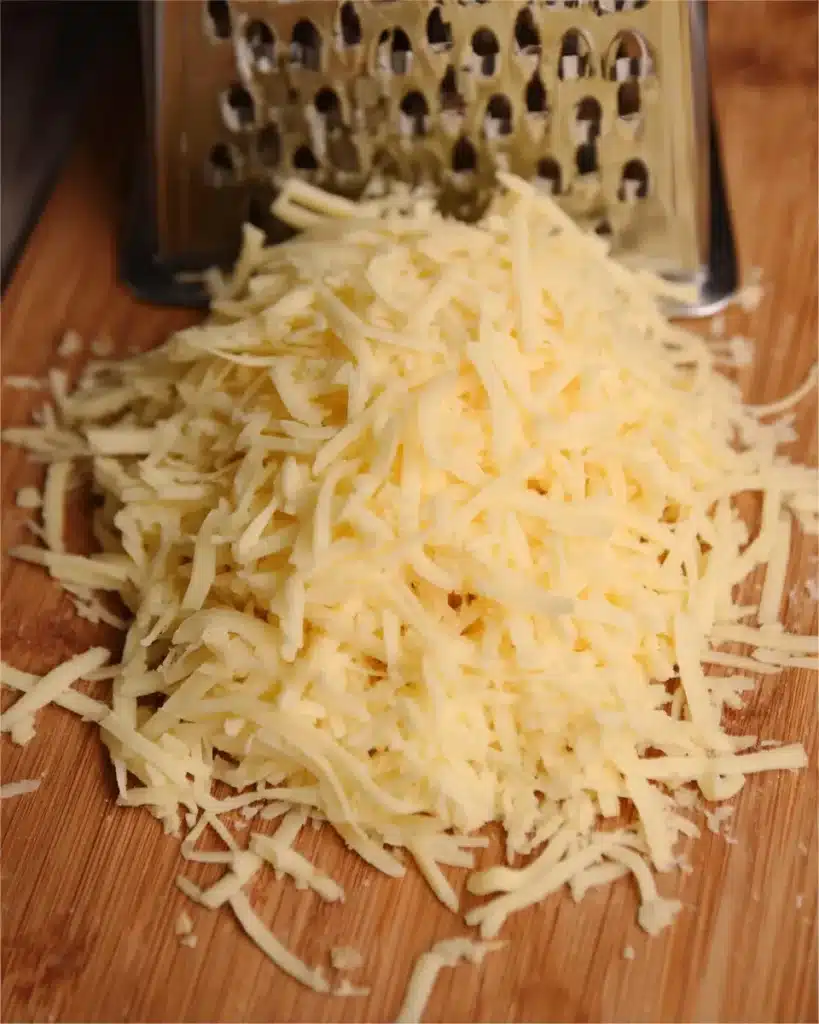 The Best Ground Beef Enchiladas Recipe Everyone Will Love 1 Freshly grated cheddar and Monterey Jack cheese on a wooden board